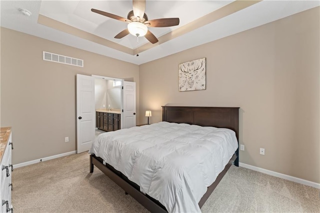 20740 W 224th St, Spring Hill, KS 66083 - bedroom featuring a tray ceiling, light carpet, ensuite bath, and ceiling fan