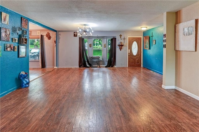 19490 Countryside Cir, Weston, MO 64098 - unfurnished living room with a textured ceiling, a chandelier, wood finished floors, and baseboards