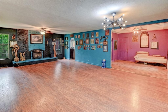 19490 Countryside Cir, Weston, MO 64098 - unfurnished living room with a ceiling fan, a textured ceiling, wood finished floors, baseboards, and a brick fireplace