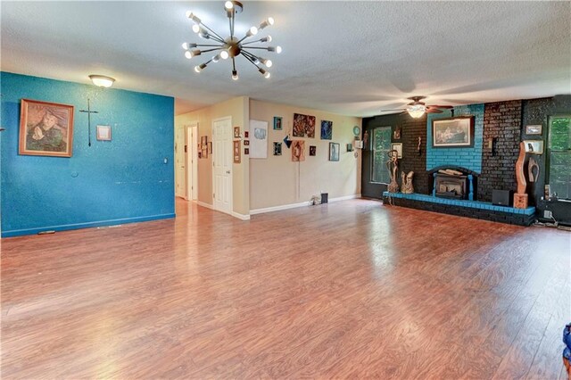 19490 Countryside Cir, Weston, MO 64098 - unfurnished living room featuring a textured ceiling, wood finished floors, a chandelier, a ceiling fan, and baseboards