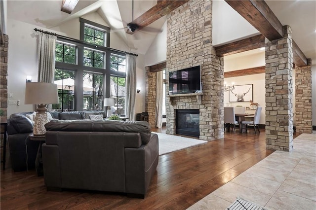 11106 W 146th Ter, Overland Park, KS 66221 - living room with beamed ceiling, a stone fireplace, hardwood / wood-style floors, high vaulted ceiling, and decorative columns