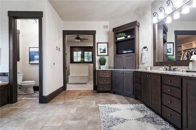 11106 W 146th Ter, Overland Park, KS 66221 - bathroom with vanity, toilet, ceiling fan, and baseboards