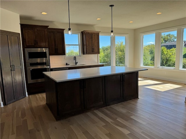 22415 87th Ter, Lenexa, KS 66227 - kitchen featuring stainless steel appliances, a sink, wood finished floors, light countertops, and recessed lighting