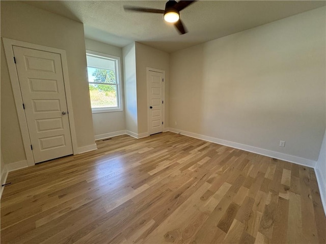 22415 87th Ter, Lenexa, KS 66227 - unfurnished room with a ceiling fan, light wood finished floors, baseboards, and a textured ceiling