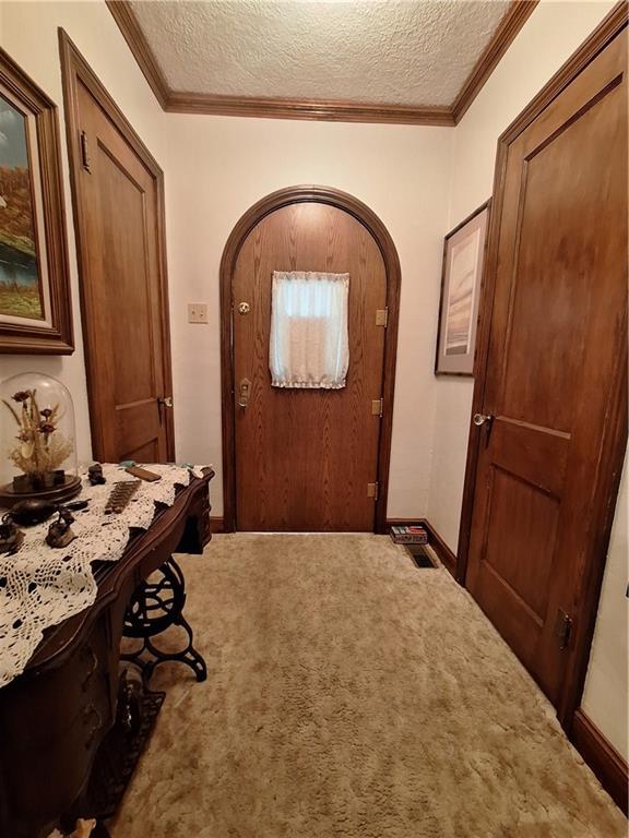 811 W Main St, Chanute, KS 66720 - hall with arched walkways, carpet flooring, baseboards, a textured ceiling, and ornamental molding