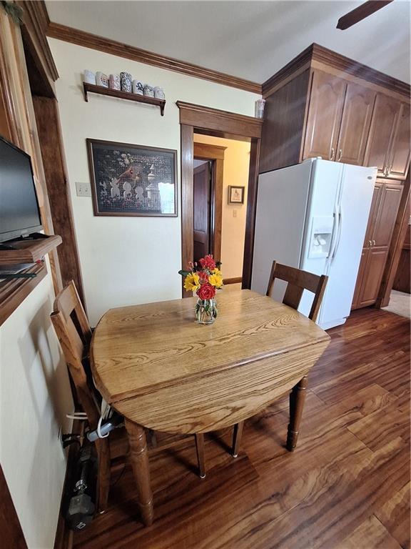 811 W Main St, Chanute, KS 66720 - dining space with dark wood-style floors, ornamental molding, and a ceiling fan