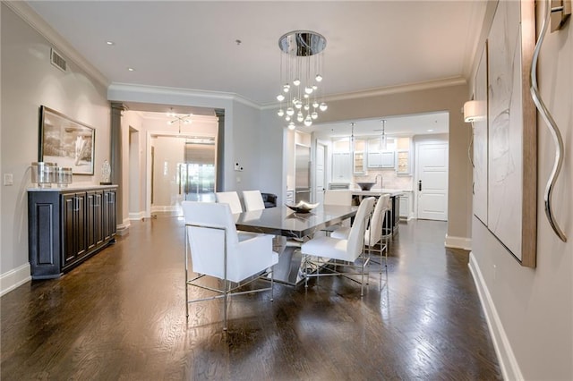 4801 W 133rd St Unit 103, Leawood, KS 66209 - dining area featuring crown molding, baseboards, dark wood finished floors, decorative columns, and a chandelier