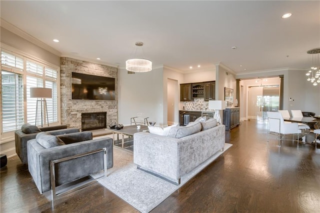 4801 W 133rd St Unit 103, Leawood, KS 66209 - living room with a stone fireplace, plenty of natural light, dark wood finished floors, a chandelier, and ornamental molding