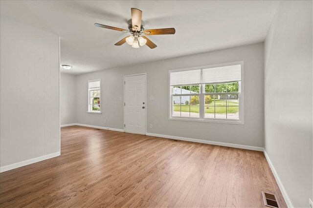 307 E 3rd Dr S, Independence, MO 64050 - empty room with plenty of natural light, wood finished floors, ceiling fan, and baseboards