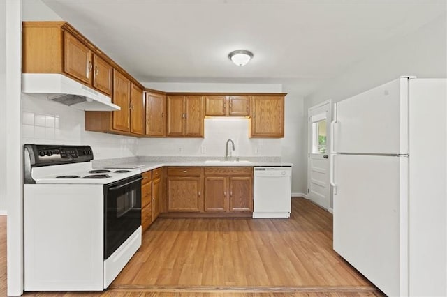 307 E 3rd Dr S, Independence, MO 64050 - kitchen with white appliances, under cabinet range hood, a sink, light countertops, and tasteful backsplash