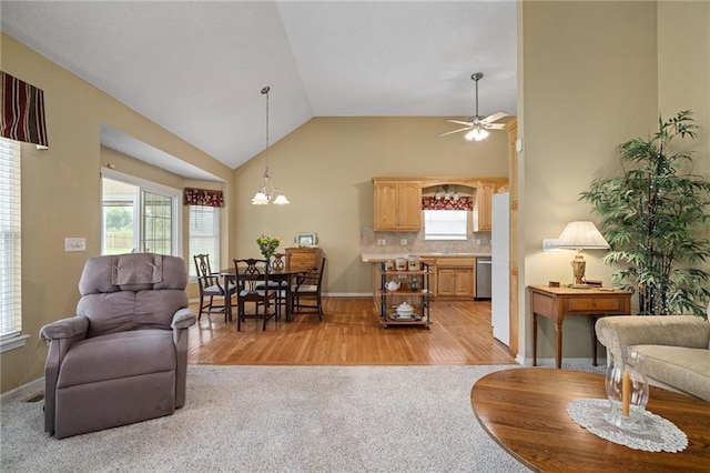 14175 W 155th St, Olathe, KS 66062 - living room featuring light wood-style flooring, a ceiling fan, a chandelier, light carpet, and high vaulted ceiling