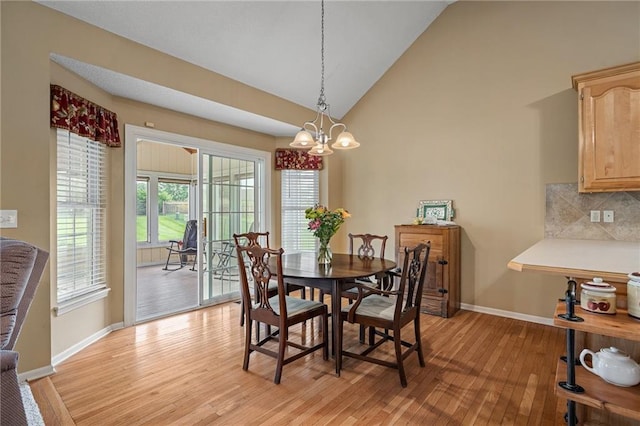 14175 W 155th St, Olathe, KS 66062 - dining space featuring light wood-style floors, baseboards, a chandelier, and high vaulted ceiling