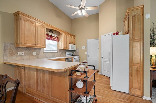 14175 W 155th St, Olathe, KS 66062 - kitchen featuring white appliances, a breakfast bar area, decorative backsplash, light wood finished floors, and light countertops