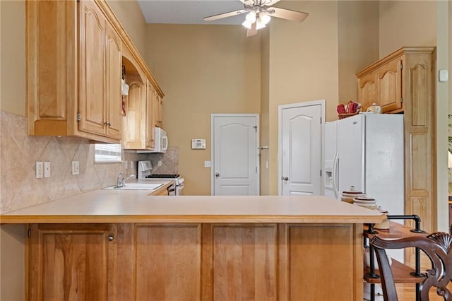 14175 W 155th St, Olathe, KS 66062 - kitchen with white appliances, a peninsula, ceiling fan, a sink, and light countertops