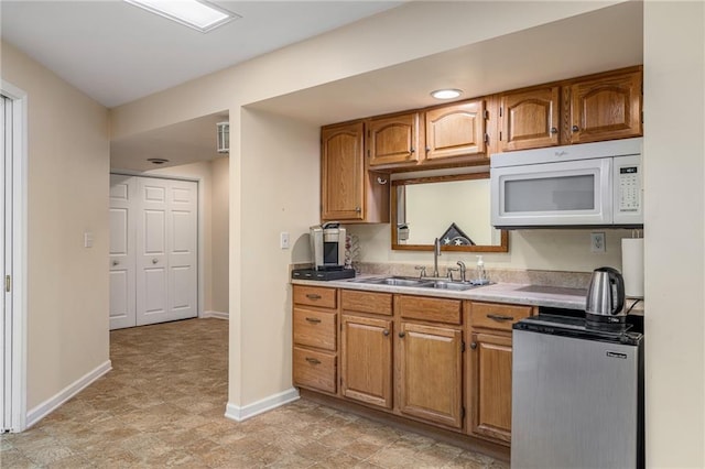 14175 W 155th St, Olathe, KS 66062 - kitchen with white microwave, a sink, and brown cabinetry