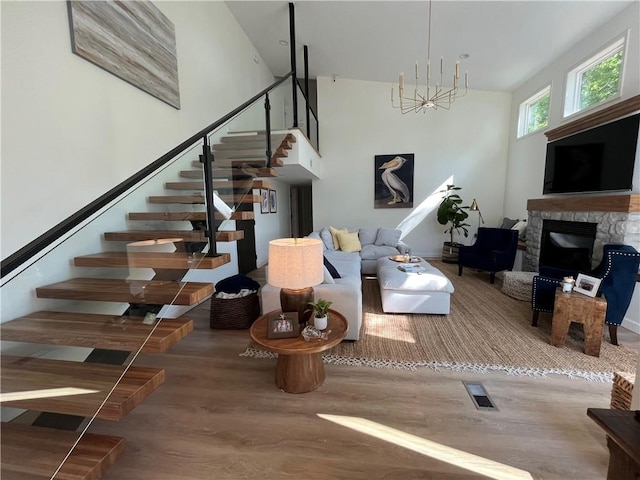 53 Z St, Lees Summit, MO 64086 - living area with stairway, wood finished floors, a stone fireplace, and a chandelier