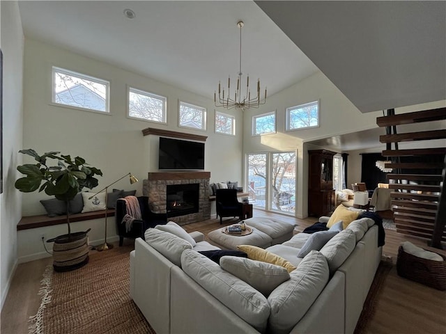 53 Z St, Lees Summit, MO 64086 - living room with a fireplace, wood finished floors, a chandelier, a towering ceiling, and baseboards