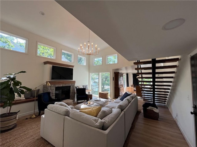 53 Z St, Lees Summit, MO 64086 - living area featuring a stone fireplace, plenty of natural light, wood finished floors, a chandelier, and a high ceiling