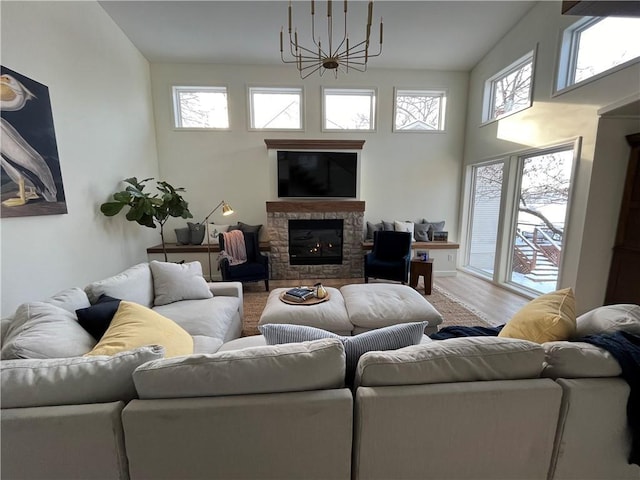 53 Z St, Lees Summit, MO 64086 - living room with a chandelier, plenty of natural light, a stone fireplace, and wood finished floors
