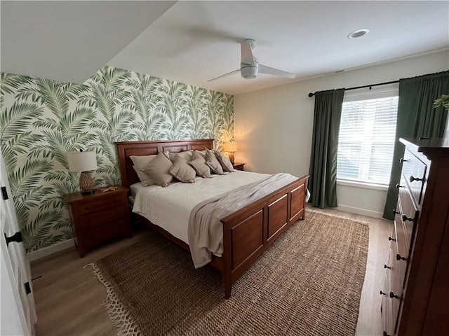 53 Z St, Lees Summit, MO 64086 - bedroom featuring wallpapered walls, an accent wall, baseboards, ceiling fan, and light wood-style flooring