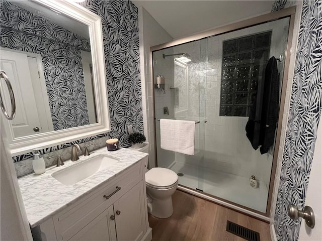 53 Z St, Lees Summit, MO 64086 - full bath with wood finished floors, toilet, wallpapered walls, a stall shower, and vanity
