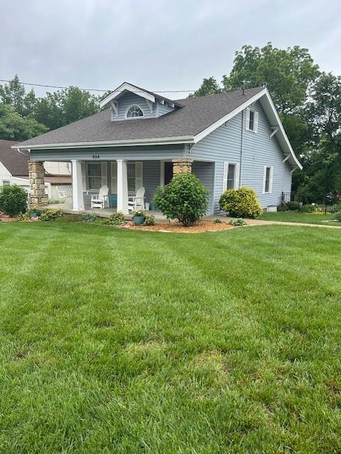 634 N Nettleton Ave, Bonner Springs, KS 66012 - view of front of home featuring a porch, a front lawn, and roof with shingles