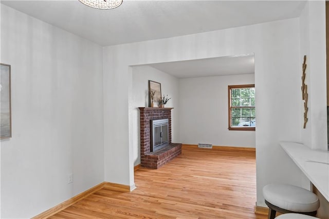 4417 E 104th St, Kansas City, MO 64137 - living area featuring light wood-style floors, a fireplace, and baseboards