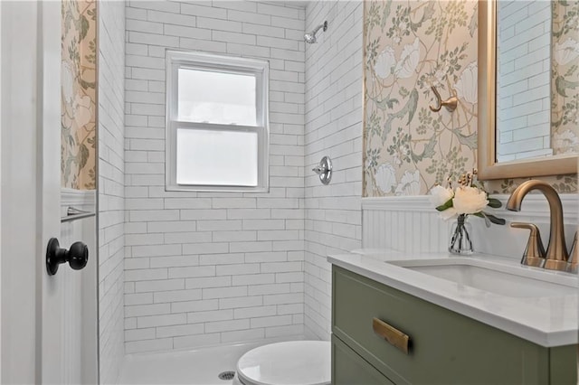 4417 E 104th St, Kansas City, MO 64137 - full bathroom featuring tiled shower, wallpapered walls, vanity, toilet, and a wainscoted wall