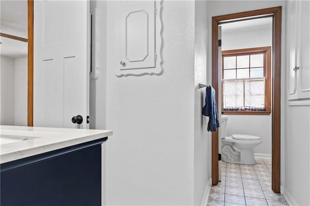 4417 E 104th St, Kansas City, MO 64137 - bathroom with toilet, baseboards, vanity, and tile patterned floors