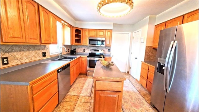 566 Lake Viking Ter, Gallatin, MO 64640 - kitchen with appliances with stainless steel finishes, a sink, a kitchen island, tasteful backsplash, and glass insert cabinets