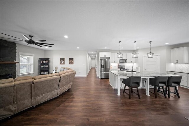 690 SW T Hwy, Holden, MO 64040 - living room with recessed lighting, dark wood-type flooring, a ceiling fan, baseboards, and a fireplace