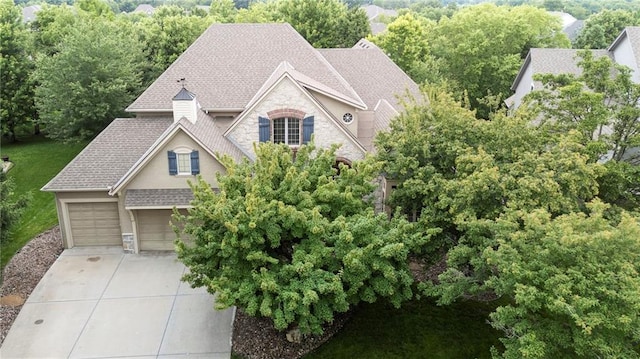 9300 W 156th Pl, Overland Park, KS 66221 - view of front of home featuring stone siding, a garage, driveway, roof with shingles, and stucco siding