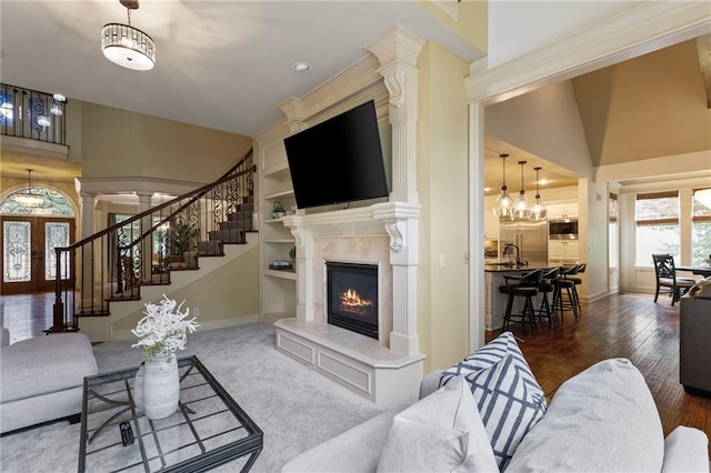 9300 W 156th Pl, Overland Park, KS 66221 - living area featuring baseboards, a premium fireplace, stairs, built in shelves, and a towering ceiling