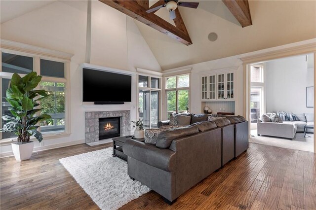 9300 W 156th Pl, Overland Park, KS 66221 - living room with high vaulted ceiling, beam ceiling, ceiling fan, a stone fireplace, and wood finished floors