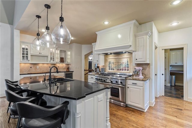 9300 W 156th Pl, Overland Park, KS 66221 - kitchen featuring high end stainless steel range oven, a sink, white cabinetry, a kitchen bar, and recessed lighting
