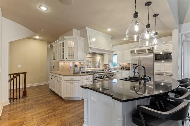 9300 W 156th Pl, Overland Park, KS 66221 - kitchen featuring built in appliances, a sink, baseboards, white cabinetry, and decorative backsplash