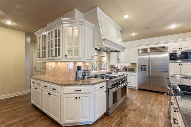 9300 W 156th Pl, Overland Park, KS 66221 - kitchen featuring built in appliances, dark wood-style flooring, custom range hood, white cabinetry, and recessed lighting