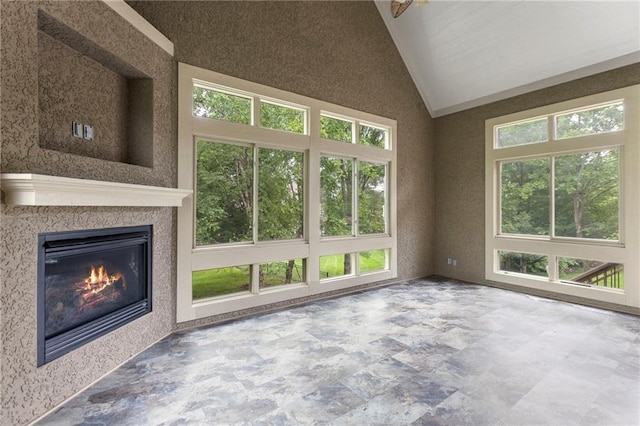 9300 W 156th Pl, Overland Park, KS 66221 - unfurnished living room with lofted ceiling, stone finish floors, and a glass covered fireplace