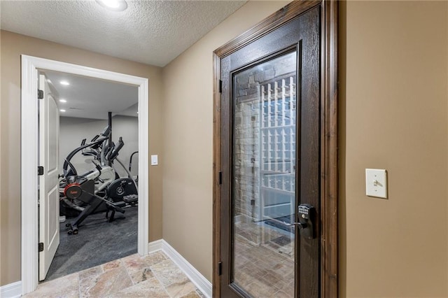 9300 W 156th Pl, Overland Park, KS 66221 - hallway with stone tile floors, baseboards, and a textured ceiling