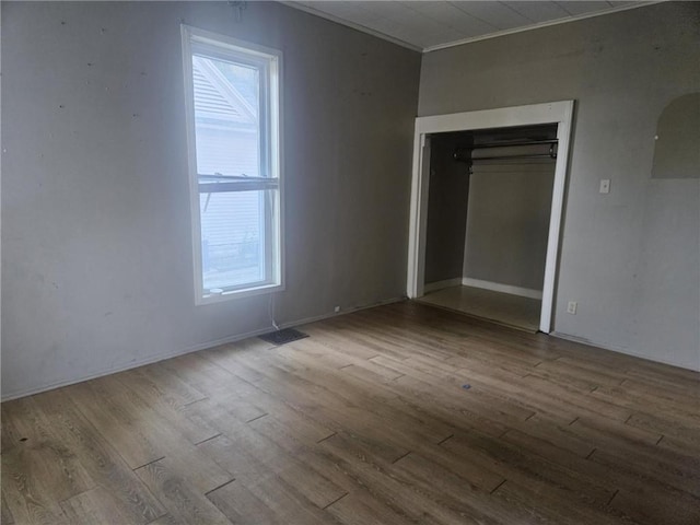 303 W Park St, Pittsburg, KS 66762 - unfurnished bedroom featuring wood finished floors, multiple windows, a closet, and crown molding