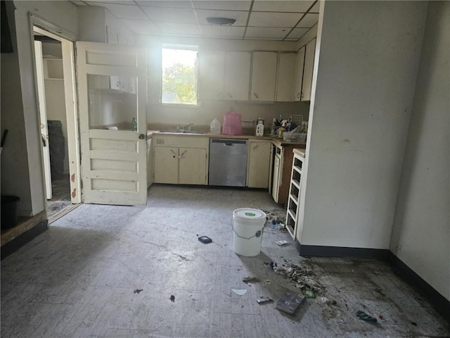 303 W Park St, Pittsburg, KS 66762 - kitchen with stainless steel dishwasher, a sink, a paneled ceiling, cream cabinetry, and light countertops