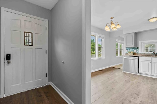 3218 NE 47th St, Kansas City, MO 64119 - entryway featuring a chandelier, baseboards, and light wood-style floors