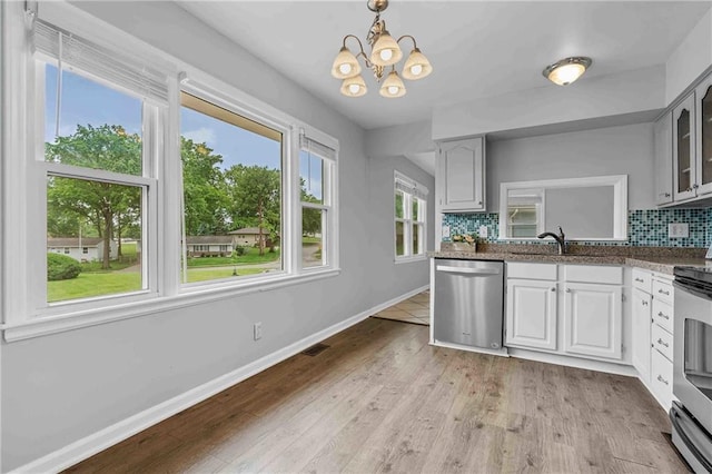 3218 NE 47th St, Kansas City, MO 64119 - kitchen with stainless steel appliances, baseboards, decorative backsplash, a sink, and glass insert cabinets