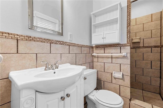3218 NE 47th St, Kansas City, MO 64119 - bathroom featuring tile walls, toilet, vanity, a wainscoted wall, and a shower