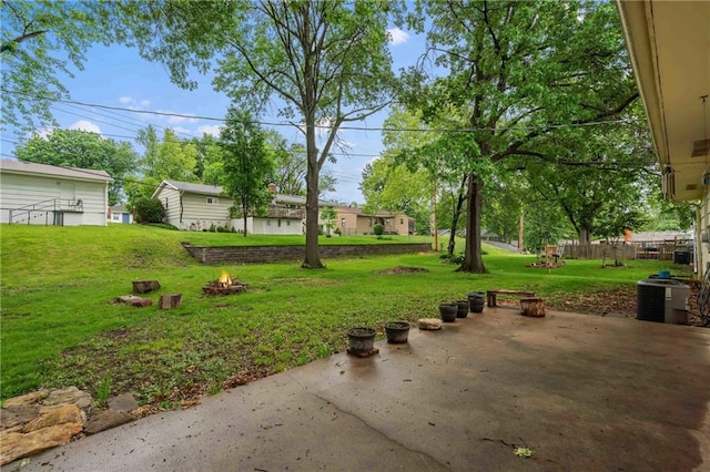3218 NE 47th St, Kansas City, MO 64119 - view of grassy yard featuring an outdoor fire pit, a patio, and central air condition unit