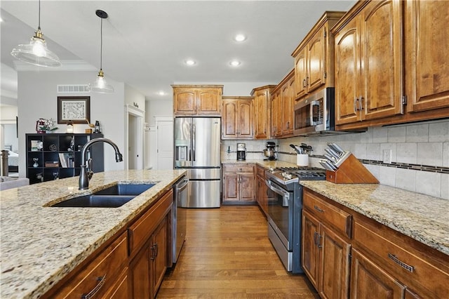 1104 NW 109th St, Kansas City, MO 64155 - kitchen with appliances with stainless steel finishes, a sink, wood finished floors, tasteful backsplash, and light stone countertops