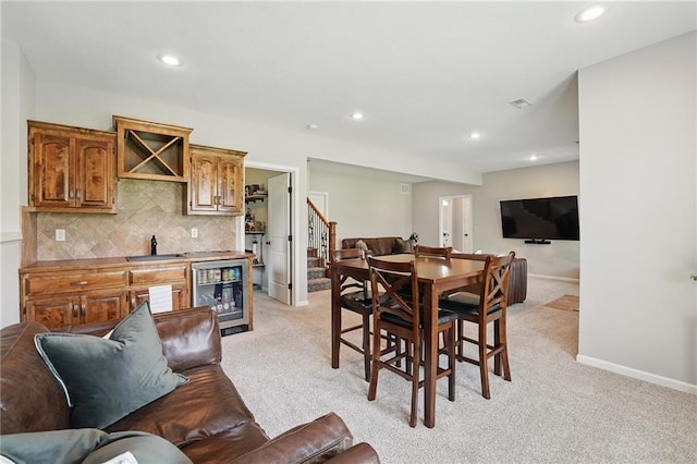 1104 NW 109th St, Kansas City, MO 64155 - dining room with wet bar, light colored carpet, recessed lighting, baseboards, and stairway