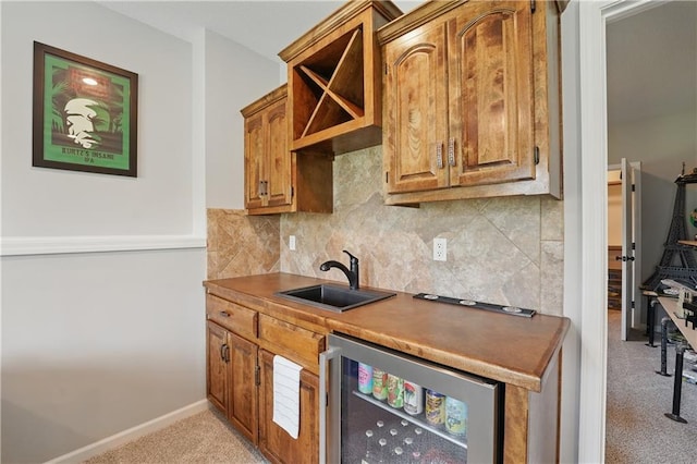 1104 NW 109th St, Kansas City, MO 64155 - kitchen with beverage cooler, a sink, light carpet, tasteful backsplash, and brown cabinets