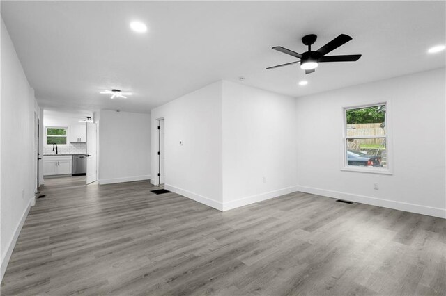 1419 Washington Blvd, Kansas City, KS 66102 - unfurnished living room featuring wood finished floors, recessed lighting, baseboards, and plenty of natural light