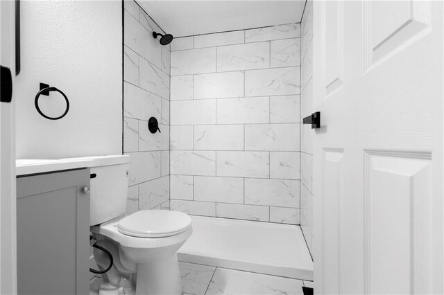 1419 Washington Blvd, Kansas City, KS 66102 - bathroom featuring marble look tiles, vanity, toilet, and tiled shower
